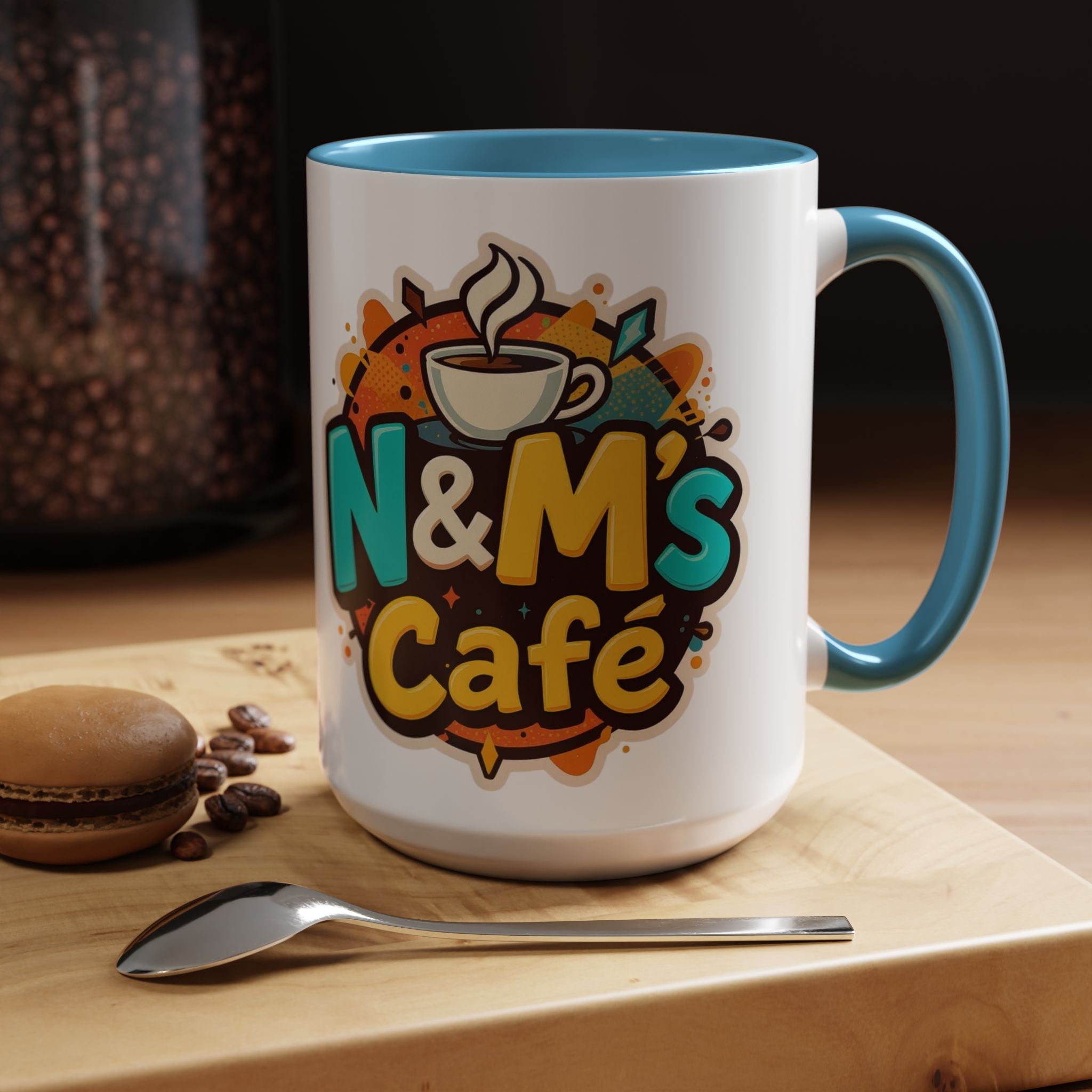 Ceramic Coffee Mug from N&M's Café with a colorful design, resting on a wooden surface with coffee beans and a spoon.